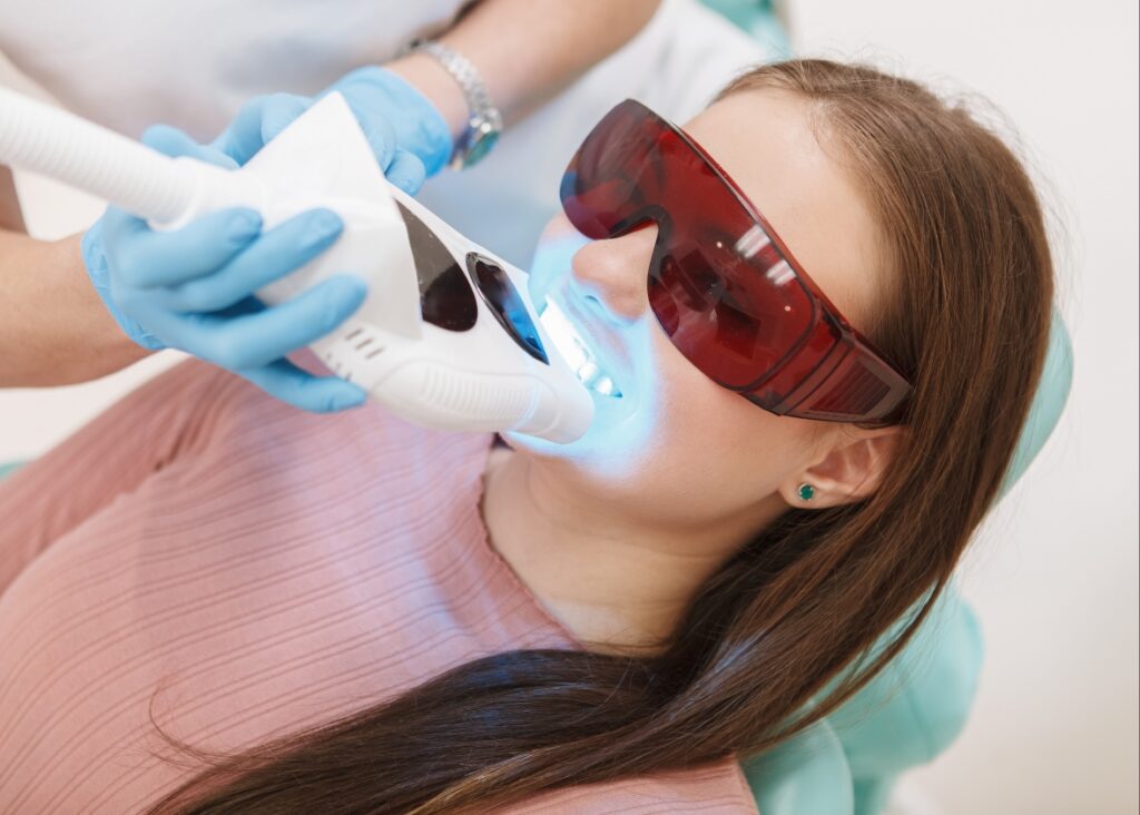 A dental specialist meticulously performs a teeth whitening procedure, ensuring optimal brightness and safety.